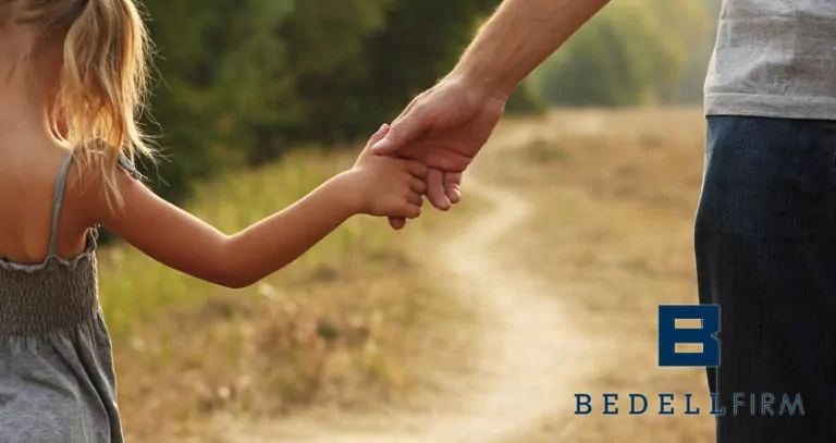 Father and daughter holding hands walking down a path