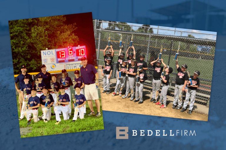 The NOL Red Sox and Jax Beach Timbler Rattlers Little League Champions holding their trophies in front of the scoreboards