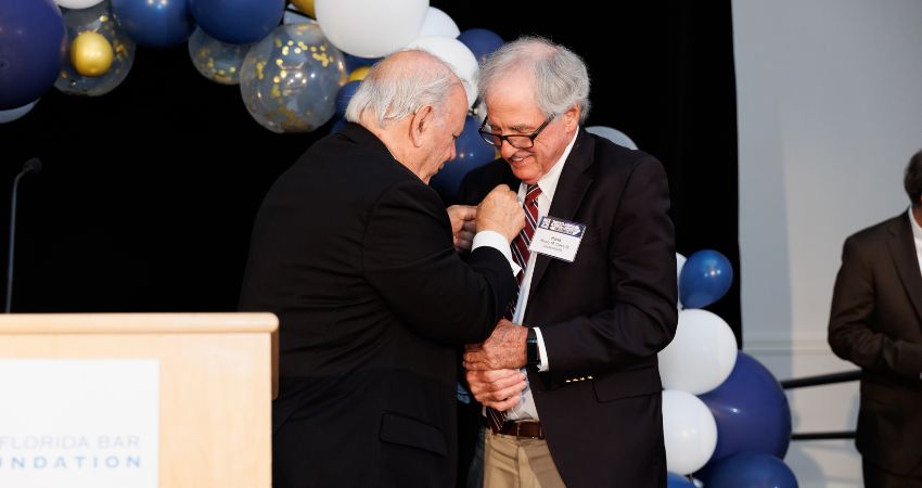 Hank Coxe accepts award lapel pin